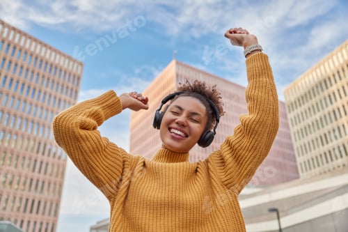 Preview: Positive Carefree Curly Haired Woman Dances With Joy Enjoys Favorite Audio Track Via Headphones