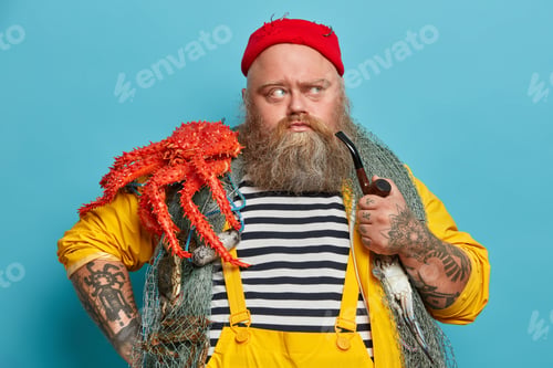 Preview: Serious Bearded Recreational Fisherman Captures Fish And Sea Creatures From Water, Looks Aside