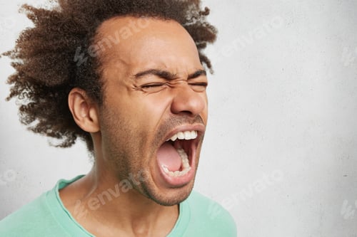 Preview: Close Up Portrait Of Mad Angry Young Dark Skinned Male Screams In Anger And Fury, Being Fed Up With