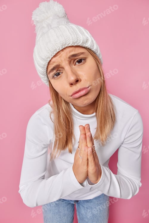 Preview: Please Help Me. Sulking Upset Young Woman Presses Palms Together Looks With Begging Expression As