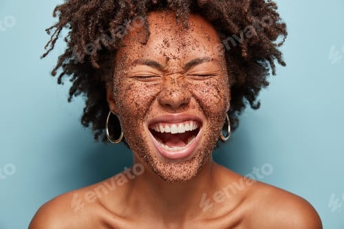 Preview: Overjoyed Woman Laughs Loudly, Cleans Face Skin With Coffee Scrub, Has Natural Mask, Crisp Hair