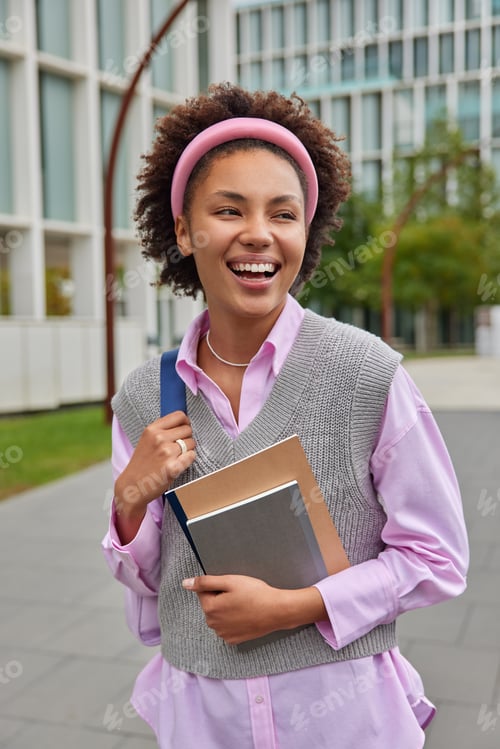 Preview: Happy American Student Strolls In College Yard Carries Rucksack And Notepads Weas Pink Shirt