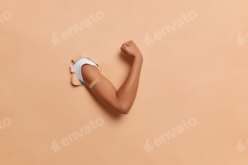 Preview: Virus Protection Concept. Faceless Human Shows Arm After Getting Injection Breaks Through Beige