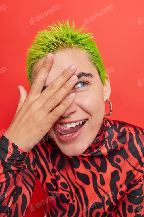 Preview: Vertical Shot Of Funny Extraordinary Hipster Girl With Green Hair Sticks Out Tongue Looks Through