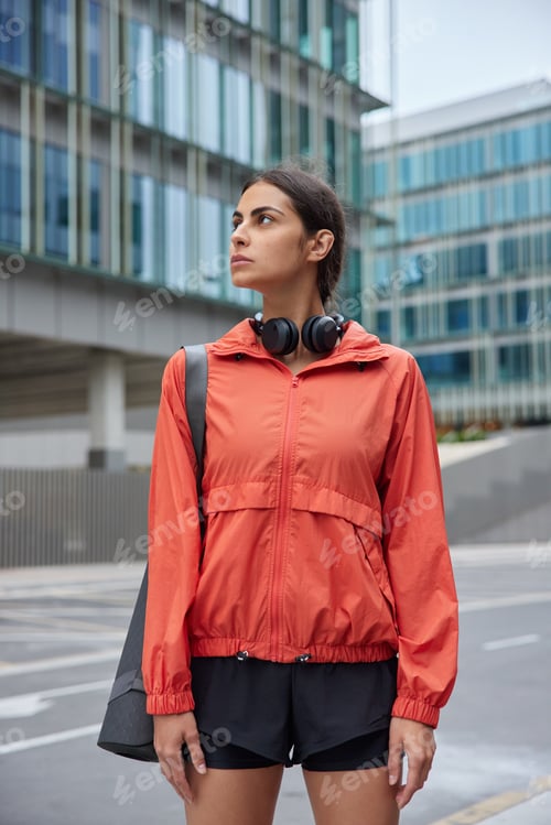 Preview: Outdoor Shot Of Young Motivated Woman In Sportswear Carries Fitness Mat Trains In Morning Has