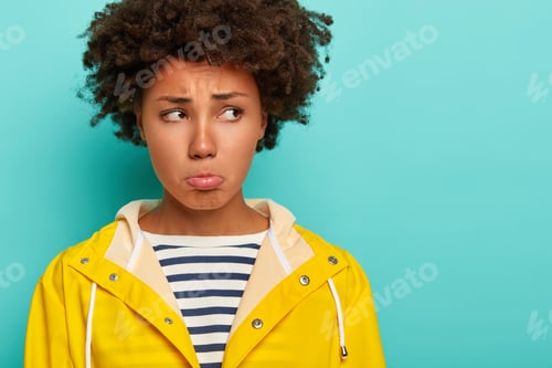 Preview: Gloomy Pity Woman With Curly Hairstyle, Has Frowning Upset Face Expression, Purses Lips And Looks