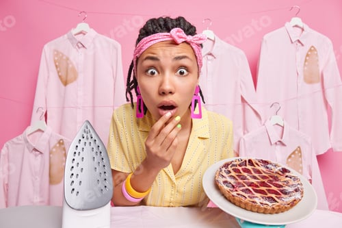 Preview: Domestic Work And Chores Concept. Stunned Dark Skinned Woman Housekeeper With Dreadlocks Stares