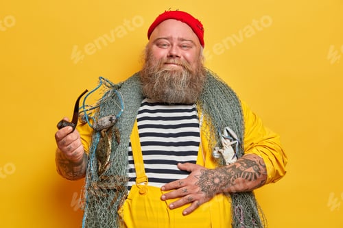 Preview: Happy Pleased Sailor Keeps Hand On Big Stomach, Smokes Pipe And Enjoys Beach Party, Poses With