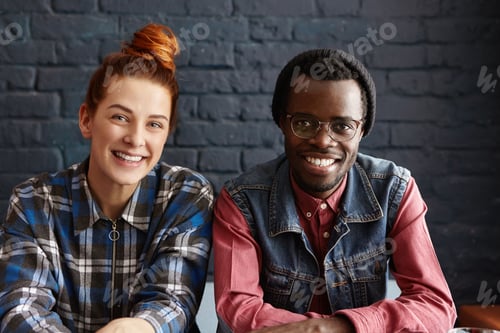 Preview: Happy Young Interracial Couple Relaxing Indoors. Cute Redhead Girl With Hair Bun Sitting Next To