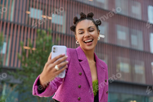 Preview: Positive Carefree Girl With Toothy Smile Takes Selfie On Smartphone Poses Against Modern Urban