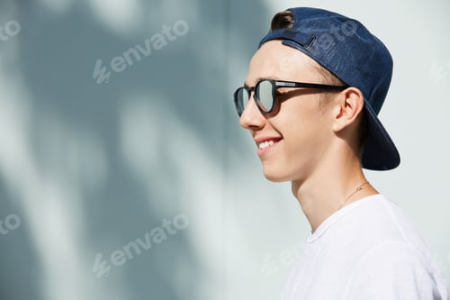 Preview: Close Up Profile Of Stylish Smiling High School Student Boy Wearing Shades And Snapback Backwards