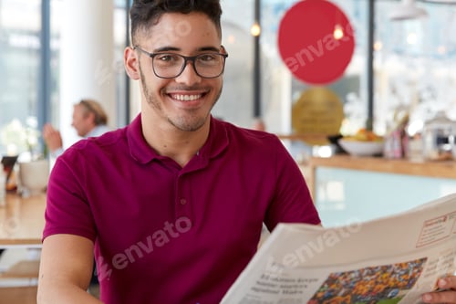 Preview: Glad Hipster Guy Wears Glasses, Has Gentle Smile On Face, Reads Good News In Newspaper During Spare