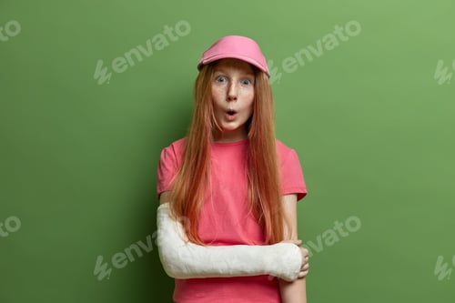 Preview: Children, Face Expressions Concept. Surprised Freckled Girl Looks With Wonder At Camera, Has Broken
