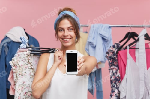 Preview: Cropped Image Of Positive Young Female Dressed Casually, Doing Shopping While Standing With Hagers