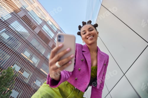 Preview: Happy Young Woman With Hairstyle Dressed In Fashionable Clothes Makes Video Call Or Selfie Via
