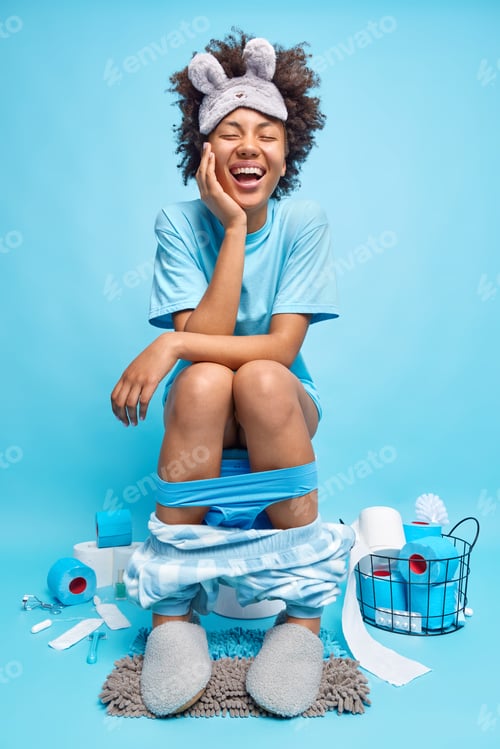 Preview: Vertical Shot Of Optimistic Curly Haired Woman Dressed In Pajama Giggles Positively Reveals Herself