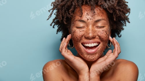 Preview: Cheerful Dark Skinned Lady Applies Coffee Scrub On Face, Pampers Skin, Closes Eyes From Pleasure
