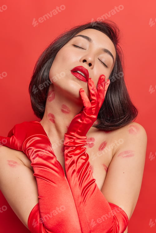 Preview: Vertical Shot Of Beautiful Thoughtful Asian Woman Keeps Eyes Closed Wears Long Red Gloves Has Well