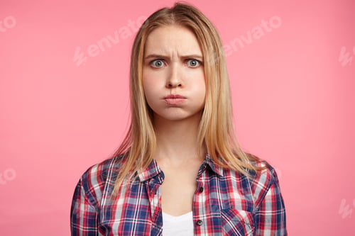 Preview: Studio Portrait Of Upset Offended Abused Blonde Female Blows Cheeks In Dissatisfaction, Finds Out