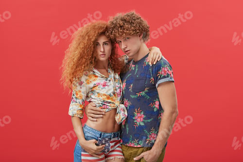 Preview: Young Handsome Guy With Curly Bushy Hair Wearing Fashionable T-Shirt Hugging His Slim Pretty