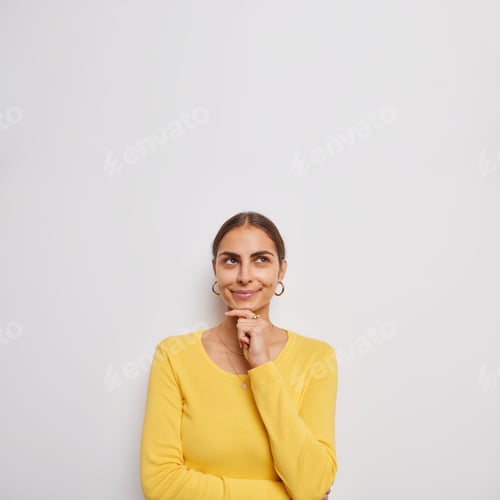 Preview: Beautiful Young Woman Ponders Something Keeps Hand On Chin Focused Above Being Deep In Thoughts