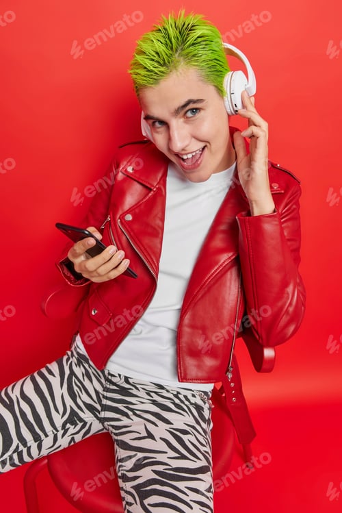 Preview: Vertical Shot Of Young Good Looking Woman With Trendy Hairstyle Listens Music Via Stereo Headphones