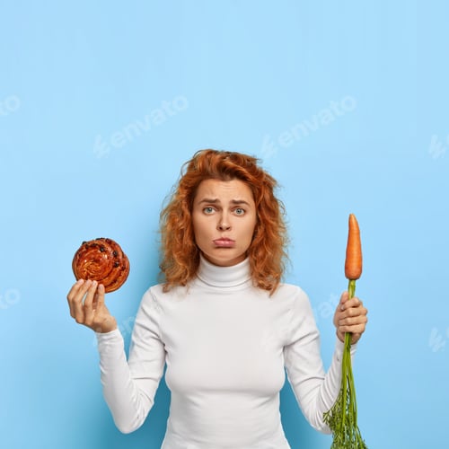 Preview: Photo Of Frustrated Disappointed Young Woman Keeps To Diet, Purses Lower Lip, Makes Hard Choice