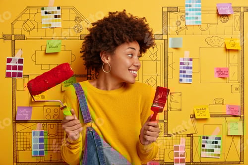 Preview: Horizontal View Of Curly Haired African American Female Decorator Holds Paint Brush And Roller