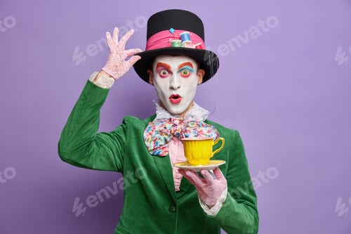 Preview: Photo Of Shocked Mad Hatter Being On Tea Party Wears Big Hat Lace Gloves And Green Costume Poses