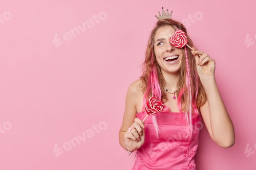 Preview: Cheerful Woman Holding Heart Lollipops on Pink Background
