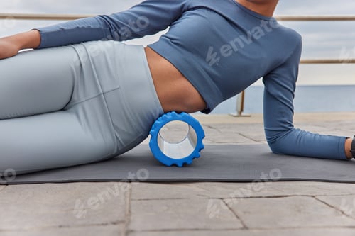 Preview: Cropped Shot Of Unrecognizable Slim Woman Uses Foam Roller For Exercising Stretches And Massages