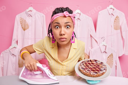 Preview: Startled African American Woman Has Shocked Expression At Camera Has Very Busy Day Irons Laundry