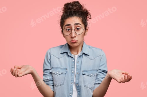 Preview: Photo Of Pretty Mixed Race Female With Puzzled Expression, Shrugs Shoulders, Has Uncertain Look