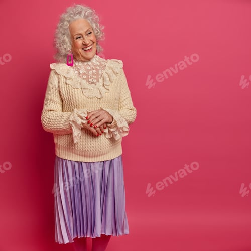Preview: Happy Elderly Woman Gets Ready For Date, Wears Fasionable Sweater And Pleated Skirt, Looks