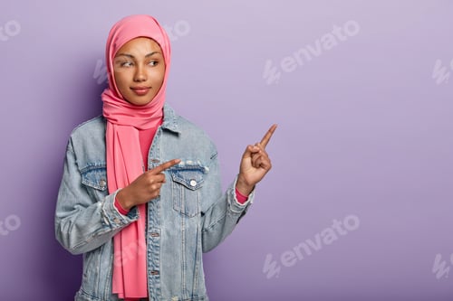 Preview: Photo Of Self Assured Arabian Lady In Traditional Pink Hijab, Shows You Right Way, Points At Blank