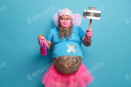 Preview: Male Cleaning Fairy Has Big Belly Poses With Detergent And Cleaning Tool, Wears Mask And Rubber