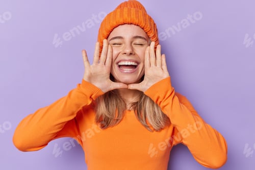 Preview: Horizontal Shot Of Cheerful Millennial Girl Keeps Hands Near Opened Mouth Whispers Good News Keeps