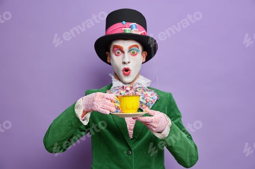 Preview: Mad Tea Party. Crazy Shocked Man Hatter Wears Large Top Hat Oversized Bowtie Lace Gloves And Green