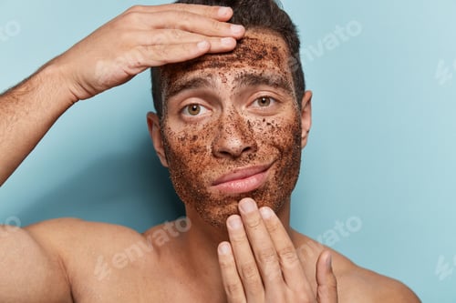 Preview: Close Up Photo Of Displeased Young Masculinity Man Has Coffee Scrub On Face, Touches Chin And