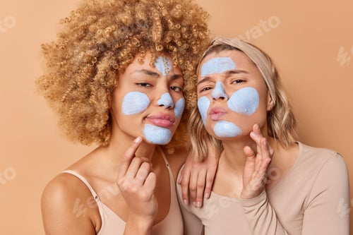 Preview: Horizontal Shot Of Serious Attentive Women Examine Condition Of Facial Skin Apply Clay Mask Take