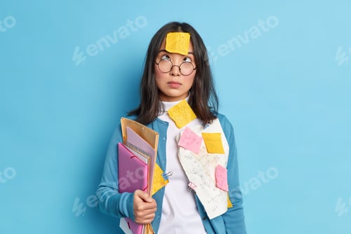 Preview: Studio Shot Of Brunette Young Asian Schoolgirl Studies Mathematics Concentrated Above On Forehead