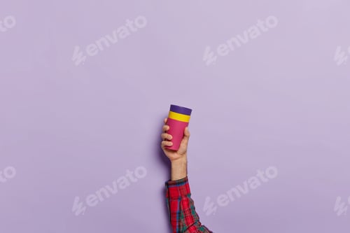 Preview: Studio Shot Of Unknown Male Person Holds Coffee Mug With Hot Beverage Over Violet Background