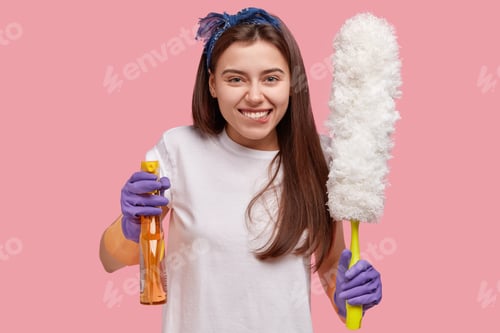 Preview: Indoor Shot Of Happy Caucasian Young Woman In White Casual T Shirt, Holds Brush For Dust And