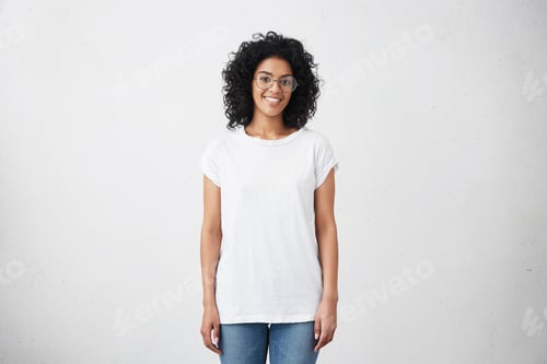 Preview: Happy Young Woman Standing At Blank White Studio Wall, Participating In Social Media Advertisement