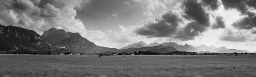 Preview: A Grayscale Panoramic Shot Of A Grassy Valley Under Cloudy Skies In Bavaria, Germmny