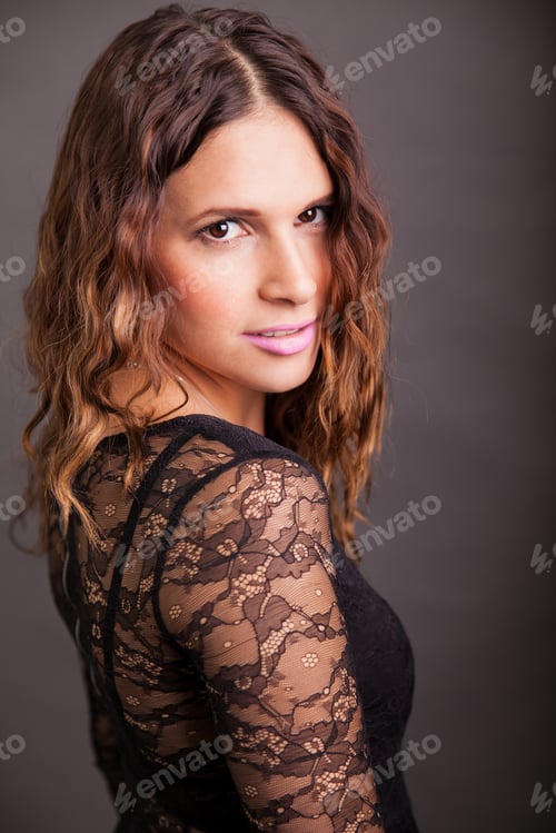 Preview: Portrait Of A Beautiful Hispanic Young Woman Wearing A Black Dress On A Gray Background