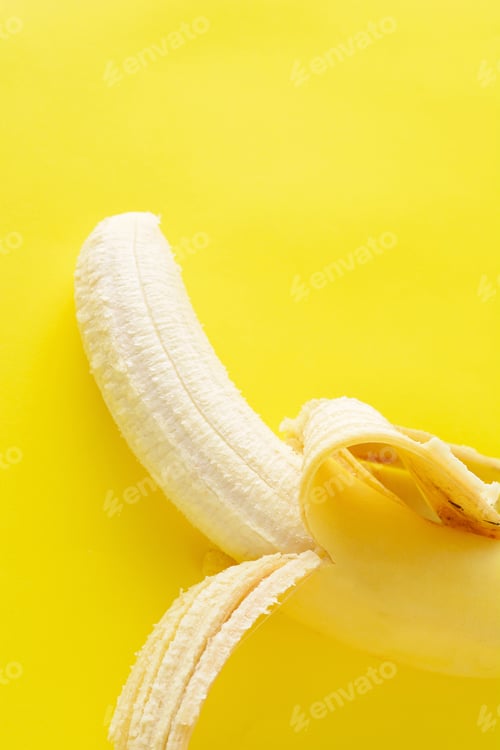 Preview: Peeled Banana On Yellow Background. Healthy Concept.