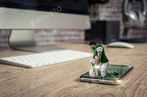 Preview: Football Player With A Green Uniform Playing And Coming Out Of A Full Screen Phone On A Wooden