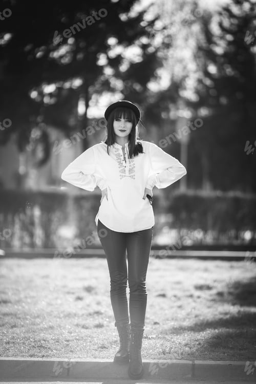 Vista previa: A Vertical Grayscale Shot Of A Beautiful Caucasian Woman Posing In A Park During Daylight