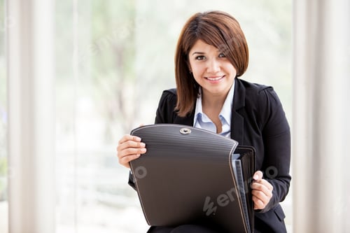 Preview: Happy Young Female Architect On A Suit Opening A Briefcase And Smiling